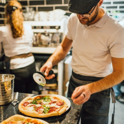 Kock skär pizza